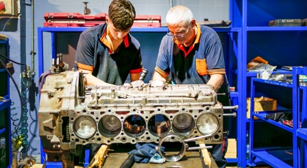 Two men fixing an engine