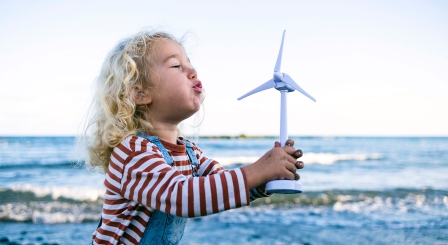 Small child blowing on windmill Sustainability Scotland
