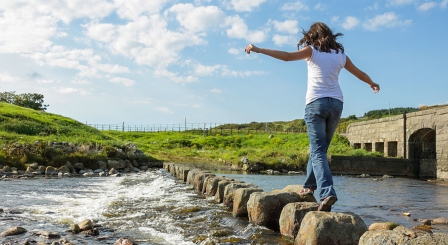 Girl walking on stepping stones