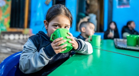 Child drinking at table