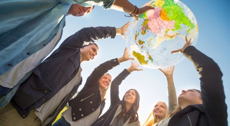 Students holding up globe