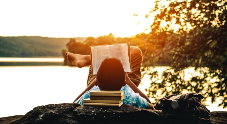boy reading by lake