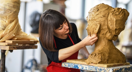 Woman sculpting a clay head