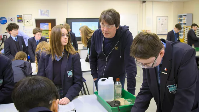 Brian Cox at a school while they do a science experiment