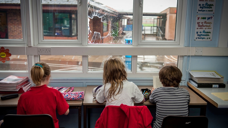 Children in classroom with broken window