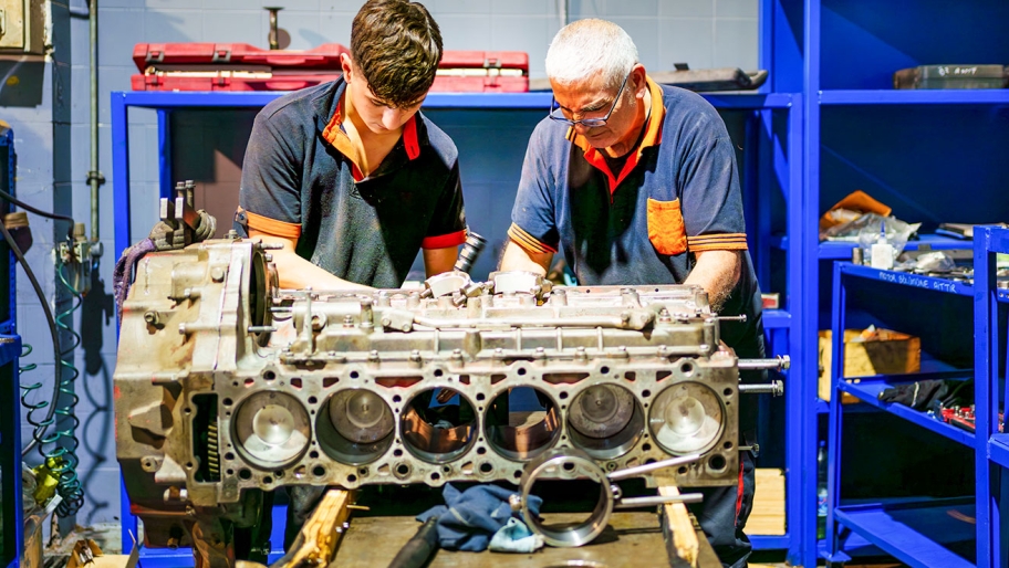 Two men fixing an engine