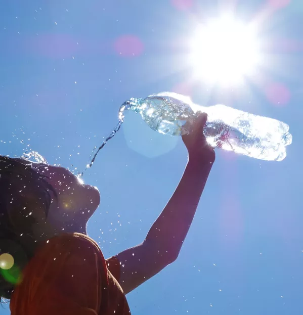 Student drinking water on hot sunny day