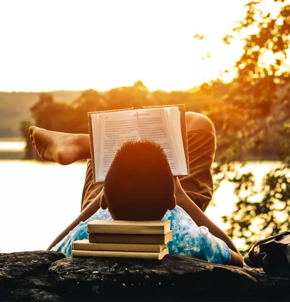 boy reading by lake