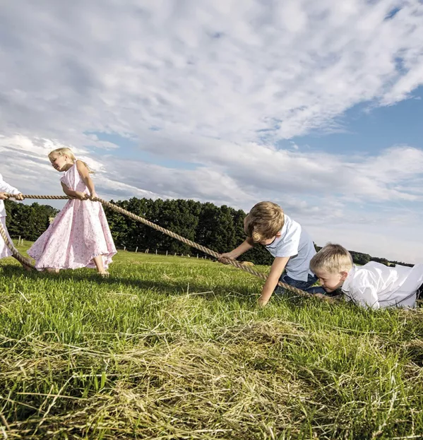 Two Girls Beating Two Boys At Tug Of War On A Grassy Hill - Gender Gap Reading