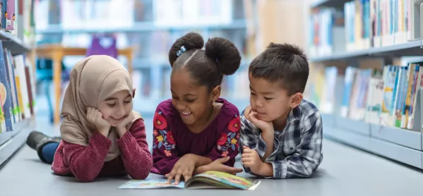 Three children reading in a school library