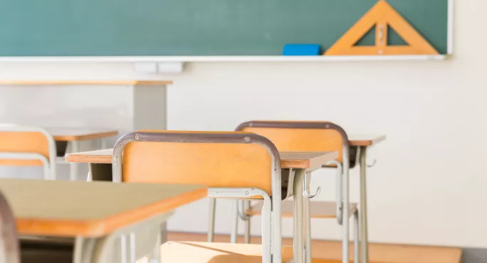 empty desks in front of blackboard
