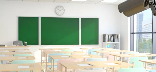 empty classroom with green chalkboard and clock above board