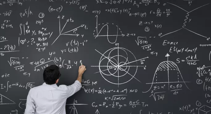 teacher standing at huge blackboard with equations