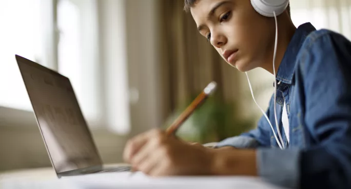 young child works at laptop