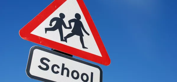 Red triangle road sign with "school"