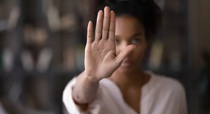 woman blurred in background holding up hand