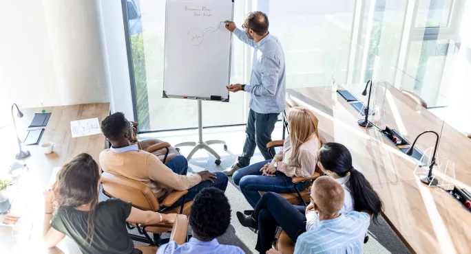 group of teachers in classroom looking at whiteboard