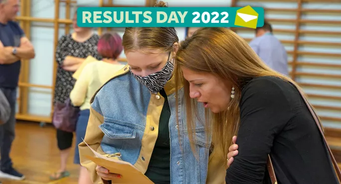 School sports hall with student in mask opening results