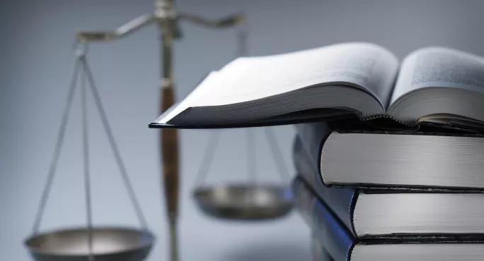 Stack Of Law Books In Front Of Scales Of Justice