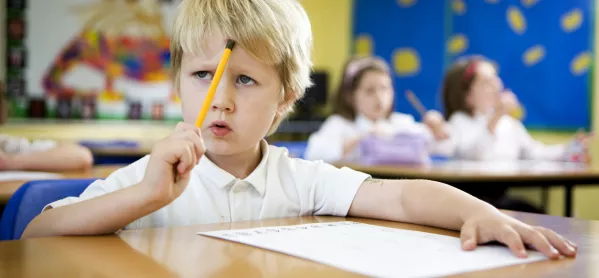 Primary school: young boy concentrating over a challenging maths problem