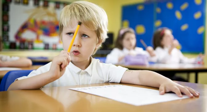 Primary school: young boy concentrating over a challenging maths problem