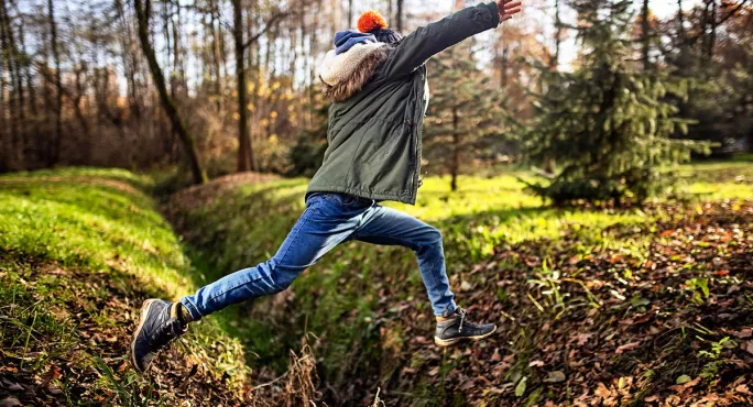 Person jumping over a ditch