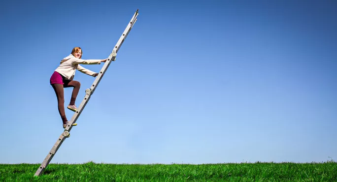 Person climbing ladder on backdrop of blue skies