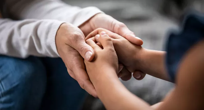 A teacher holding a child's hands