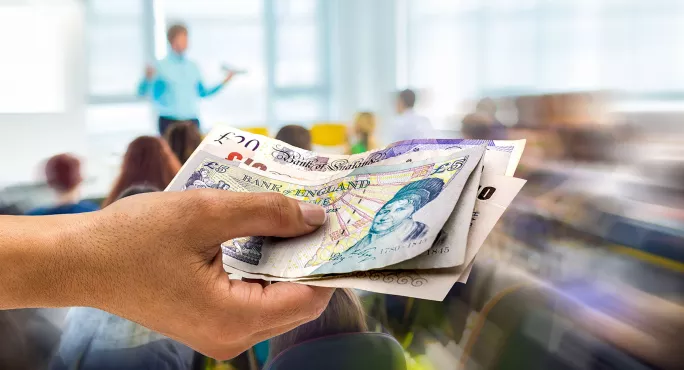 Hand with money in classroom