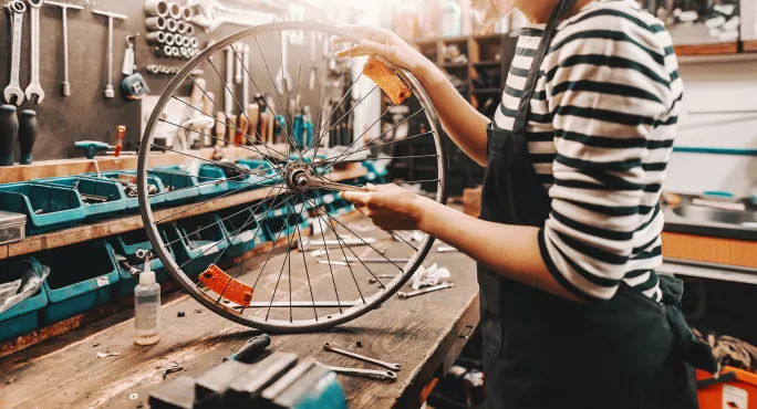 person working with bicycle wheel