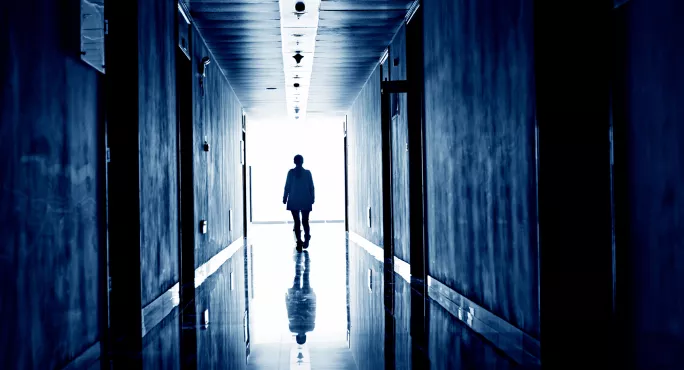 Person walking down dark corridor