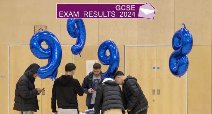 Several teenage boys looking at a table with balloons of 9s and 8s in the background