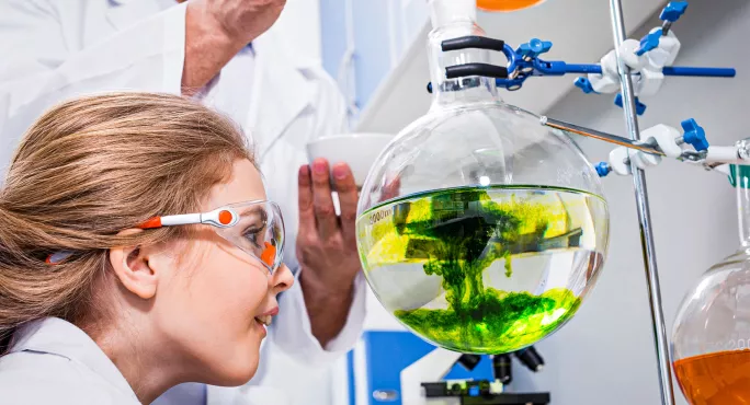 Teacher showing pupil a chemistry experiment