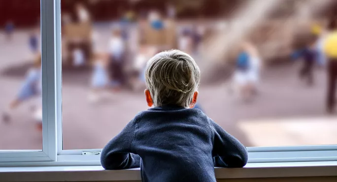 Child looking out of window at playground