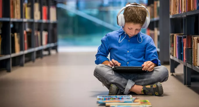 Child listening to audio in library