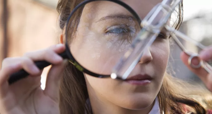 Girl looking at something in a magnifying glass - the subject is blurry