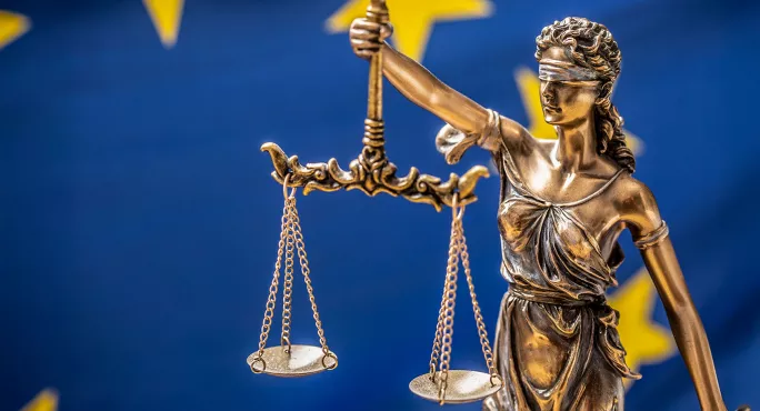 Scales of justice with Euro flag in background