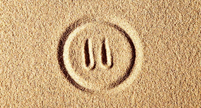 Pause button in sand