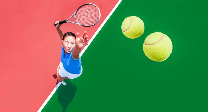 Female tennis player serving with two tennis balls