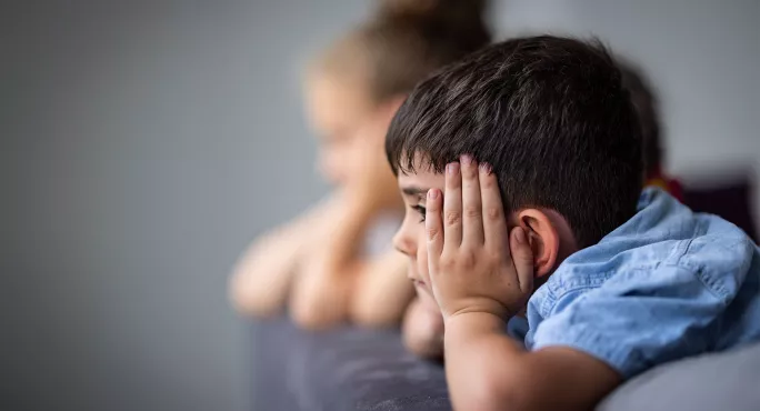 Two children staring out a window