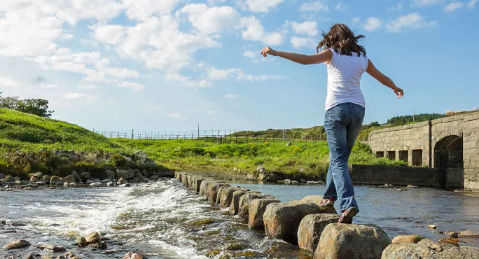 Girl walking on stepping stones