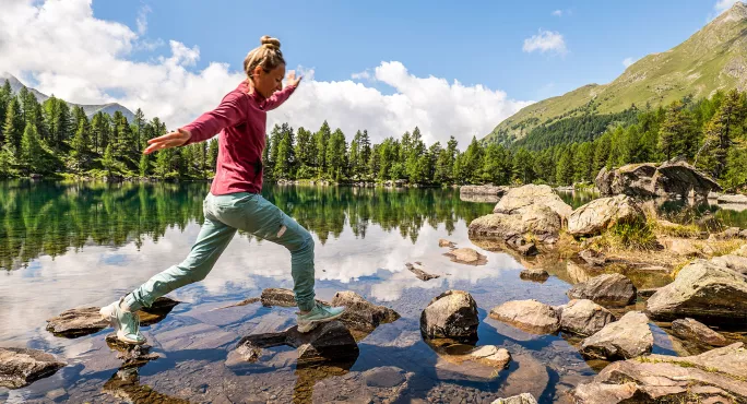 Woman stepping across a stream