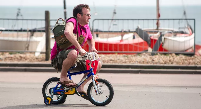 Man on child's bike