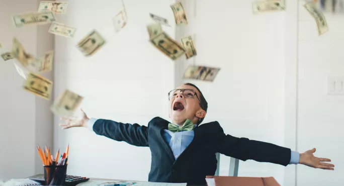 Boy At Desk, With Cash Raining Down On Him