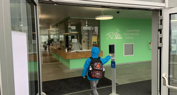 Child Sanitising Their Hands On The Way Into School In Denmark