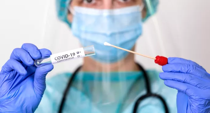 Medical Professional, In Ppe, Holds Covid Test Swab