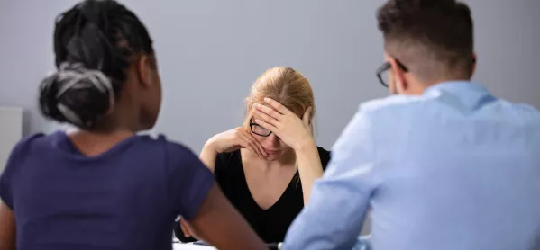 Woman Looks Upset In Meeting; Two Managers Sit Opposite Her