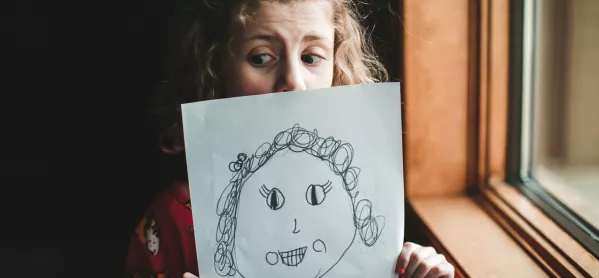 Wellbeing: Worried Looking Girl Holding Drawing Of A Girl