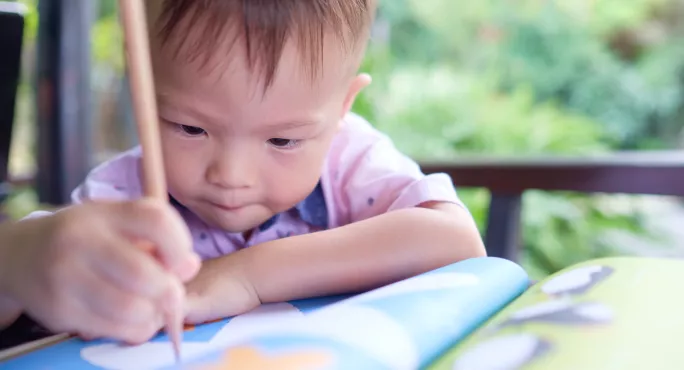 Child Drawing In Book