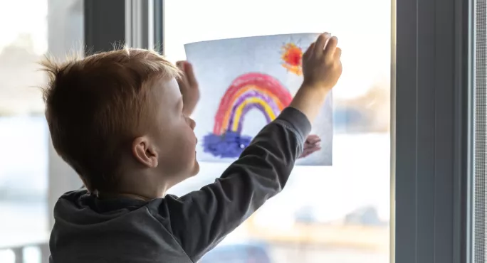 Child Sticking Photo On Window